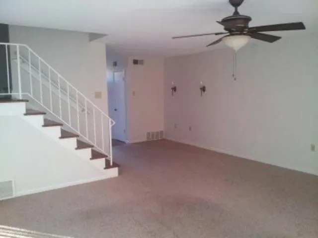 a view of an empty room with staircase