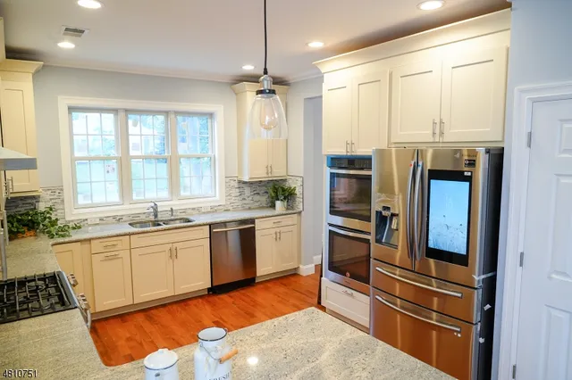 a kitchen with stainless steel appliances granite countertop a stove and a refrigerator