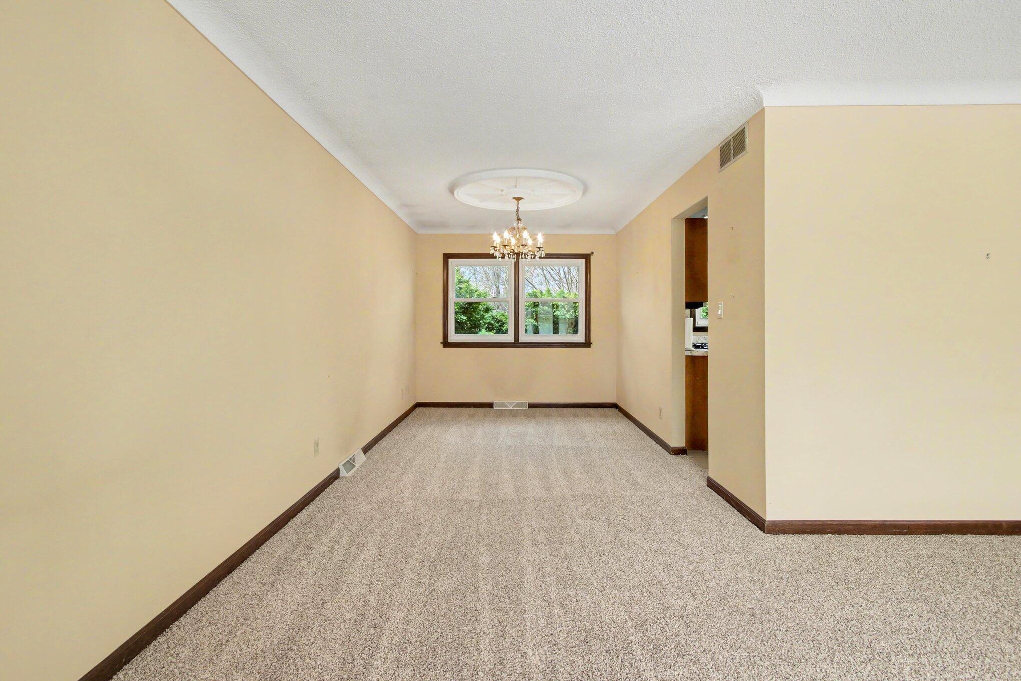 1379 Leeward Road Crown Point, IN 46307 - Photo 9 of 39 an empty room with windows and chandelier