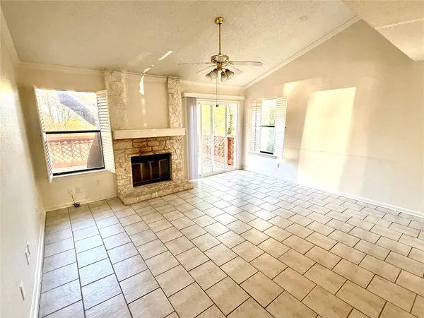 a big room with windows chandelier and fireplace