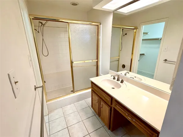 a spacious bathroom with a shower sink and mirror