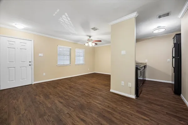 an empty room with wooden floor and windows