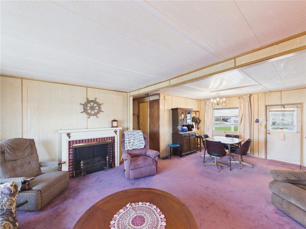6135 98th Lane Sebastian, FL 32958 - Photo 11 of 18 a living room with furniture a fireplace and a large window