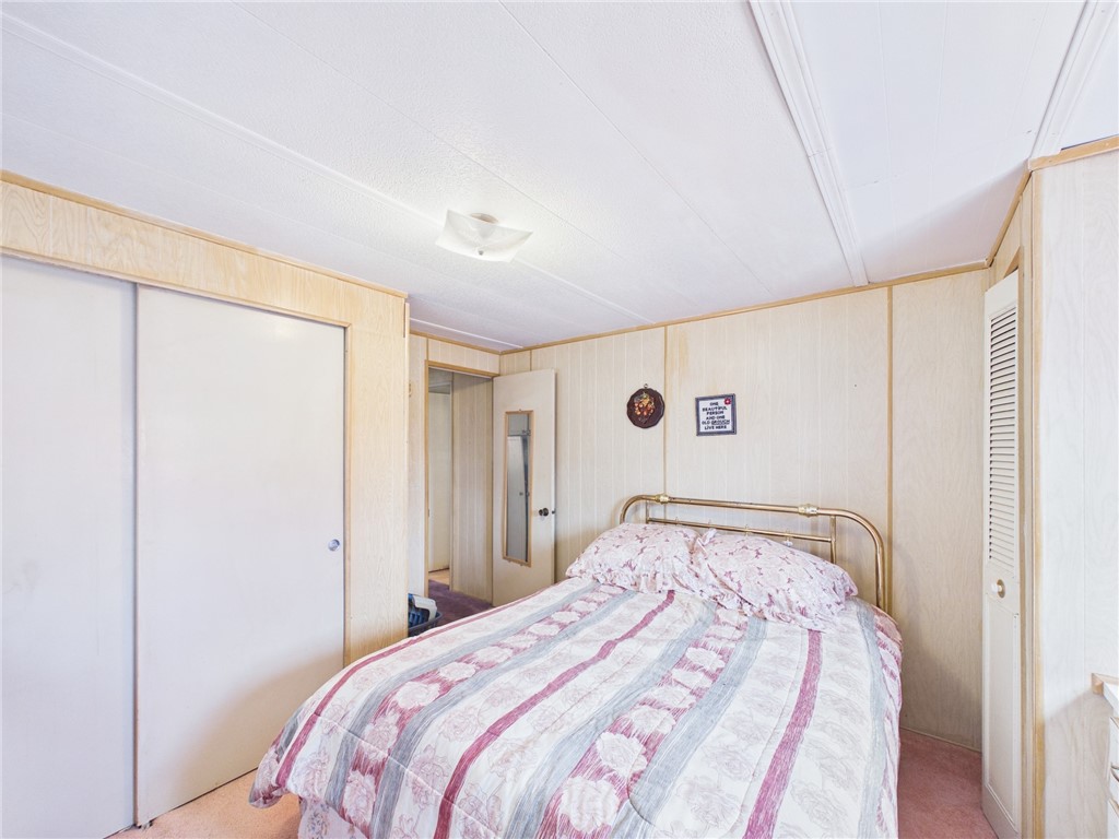 6135 98th Lane Sebastian, FL 32958 - Photo 17 of 18 a bedroom with a large bed and a chandelier fan