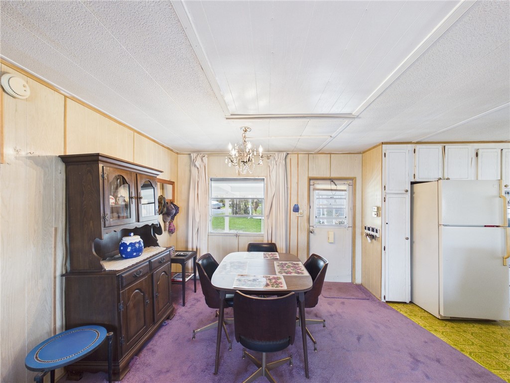 6135 98th Lane Sebastian, FL 32958 - Photo 5 of 18 a living room with furniture a dining table and a refrigerator