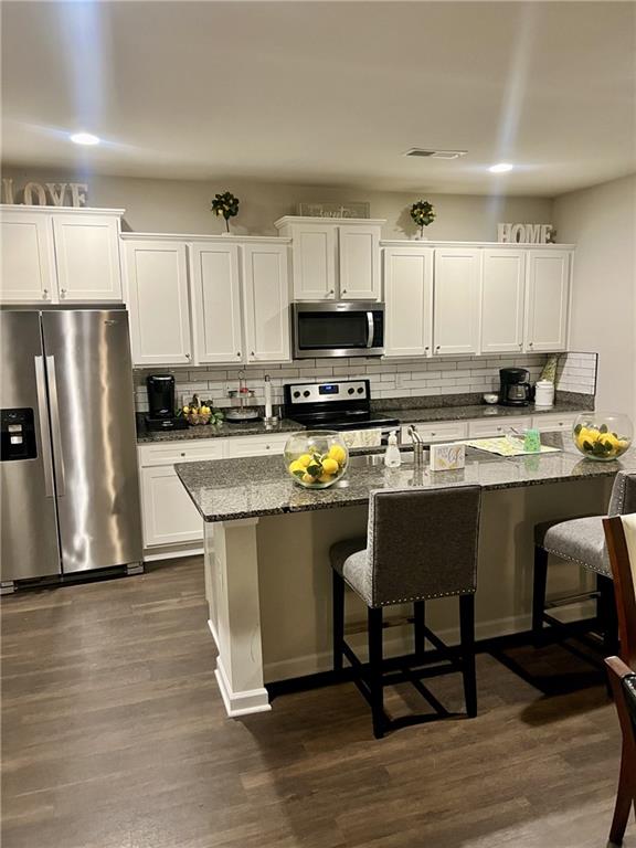 270 Wellbrook Drive Covington, GA 30016 - Photo 5 of 11 a kitchen with stainless steel appliances granite countertop a stove a sink a microwave a refrigerator and white cabinets