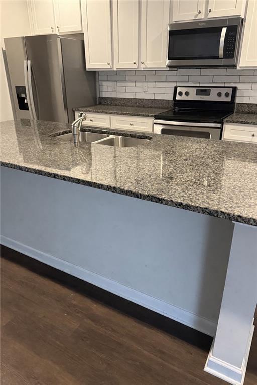 270 Wellbrook Drive Covington, GA 30016 - Photo 6 of 11 a kitchen with stainless steel appliances granite countertop a sink a stove and a microwave