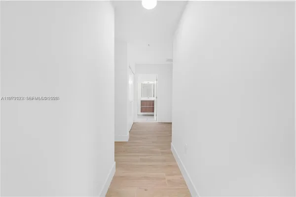 a view of a hallway with wooden floor