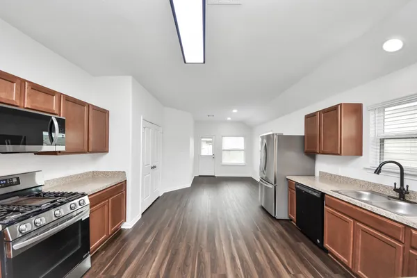 a kitchen with stainless steel appliances granite countertop a sink stove and refrigerator