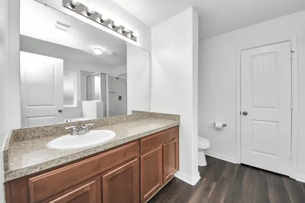 a bathroom with a granite countertop sink a toilet and a mirror