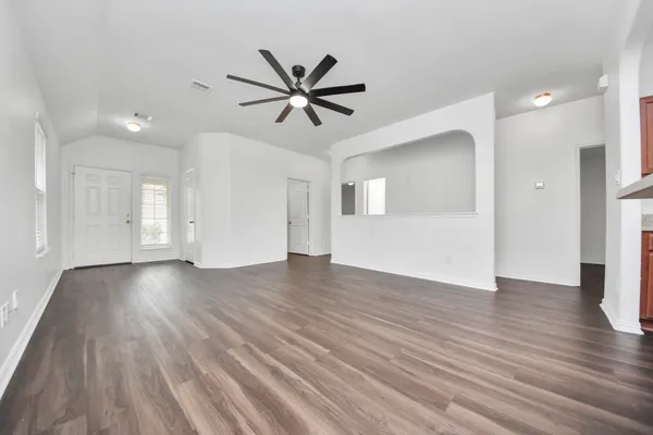 a view of empty room with wooden floor and window