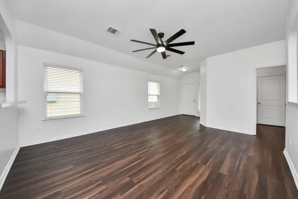 a view of empty room with wooden floor and window