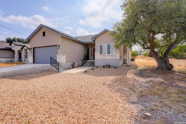a front view of house with yard and trees in the background