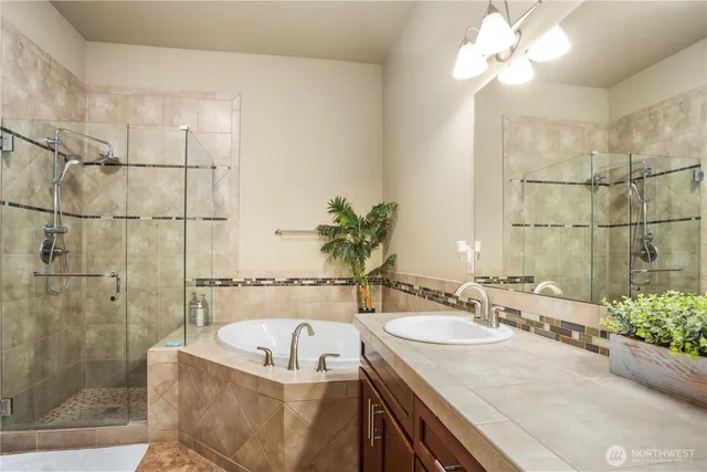 a bathroom with a granite countertop sink a bathtub and shower