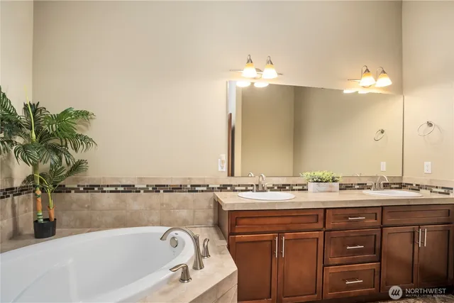 a bathroom with a tub sink and mirror