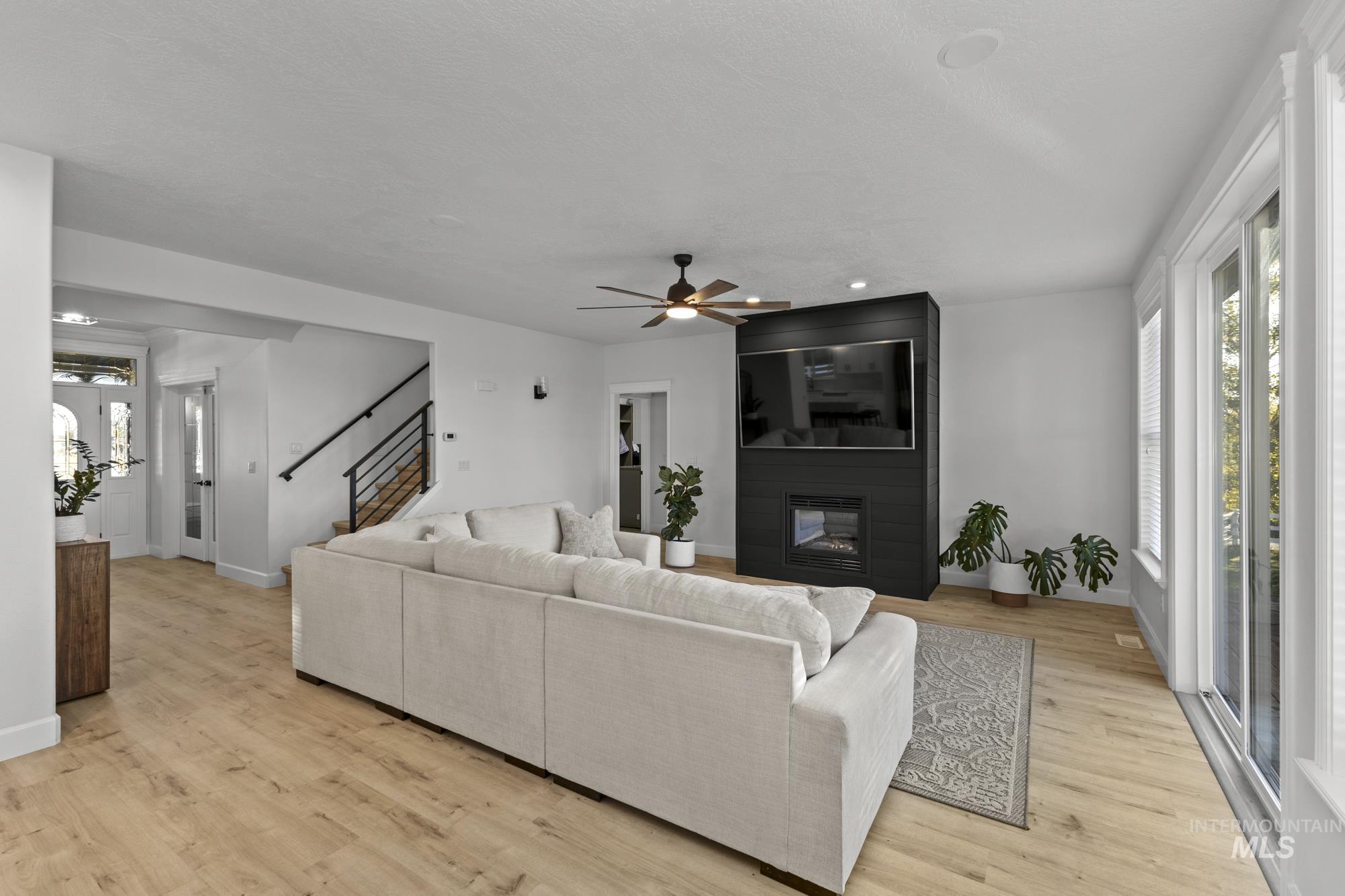 14820 Worden Way Caldwell, ID 83607 - Photo 11 of 44 Living area with light wood-style floors, a fireplace, a ceiling fan, stairs, and recessed lighting