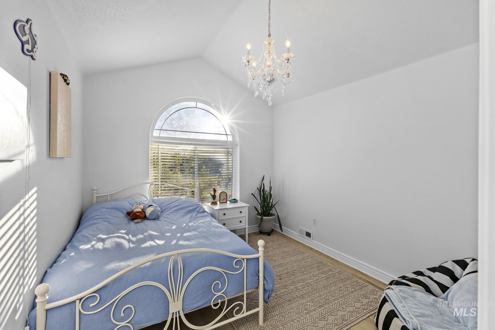 14820 Worden Way Caldwell, ID 83607 - Photo 29 of 44 Bedroom with lofted ceiling, a chandelier, and wood finished floors