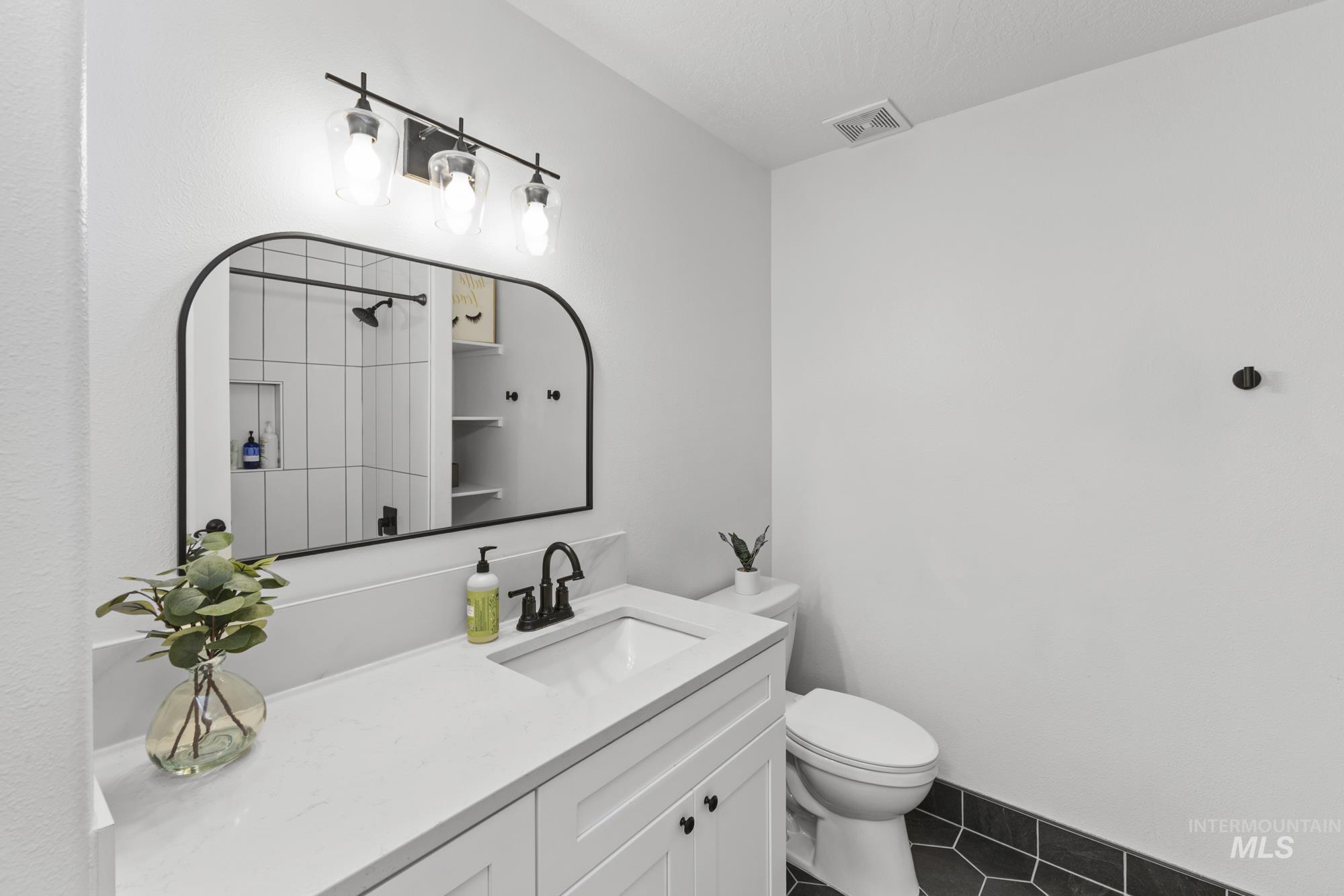 14820 Worden Way Caldwell, ID 83607 - Photo 30 of 44 Bathroom with vanity, dark tile patterned floors, and a shower