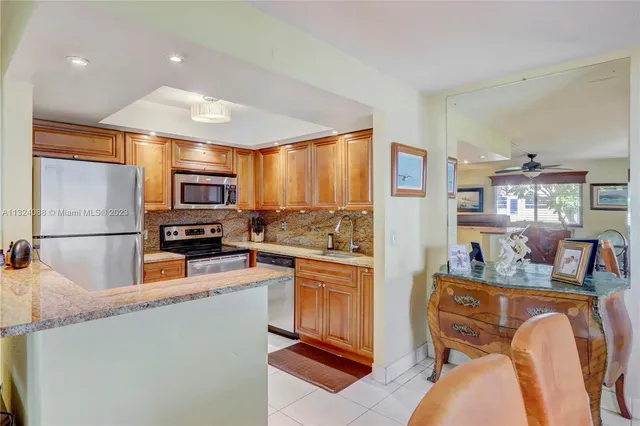 a kitchen with stainless steel appliances granite countertop a refrigerator sink stove microwave and cabinets