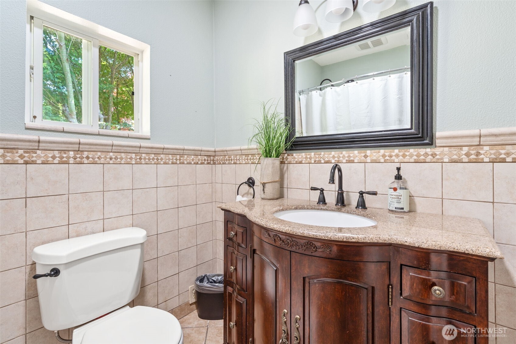 719 Peters Street Raymond, WA 98577 - Photo 15 of 36 a bathroom with a toilet a sink a mirror and a window