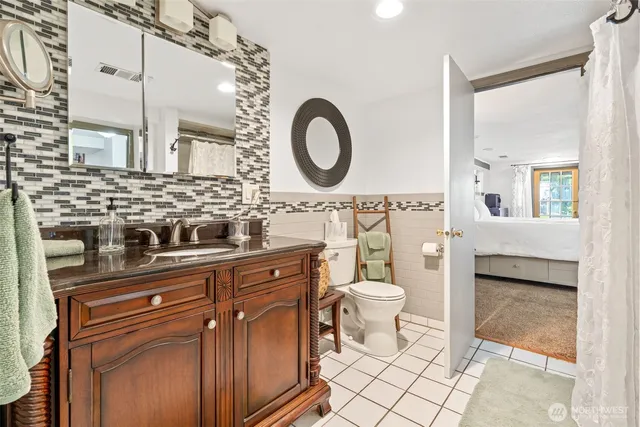a spacious bathroom with a toilet a sink a mirror and bathtub