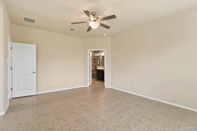 an empty room with closet and a ceiling fan