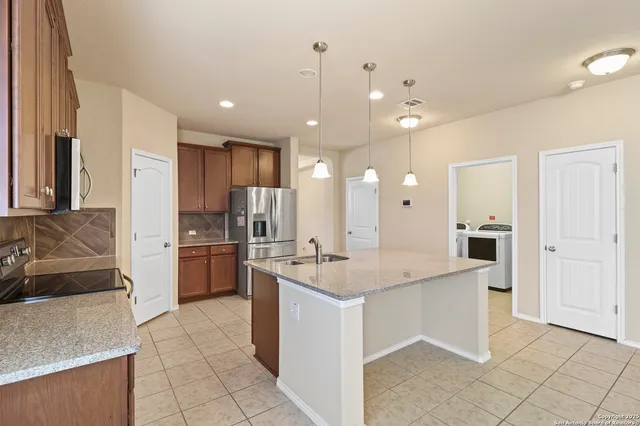 a kitchen with kitchen island a sink stainless steel appliances and cabinets