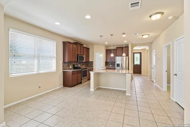 a large kitchen with a large counter top stainless steel appliances and cabinets
