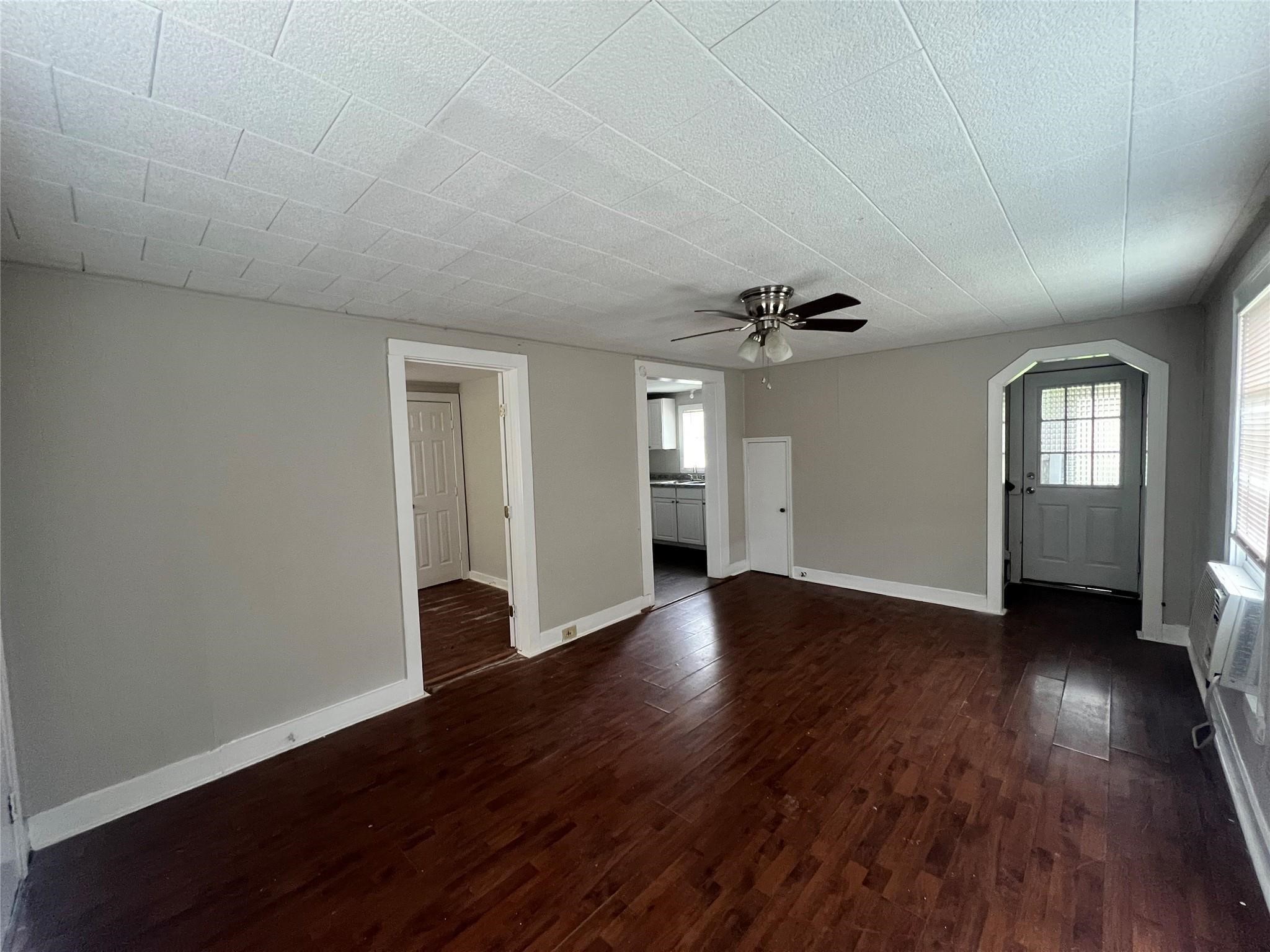 312 South Pumphrey Street Edna, TX 77957 - Photo 11 of 12 an empty room with wooden floor and windows