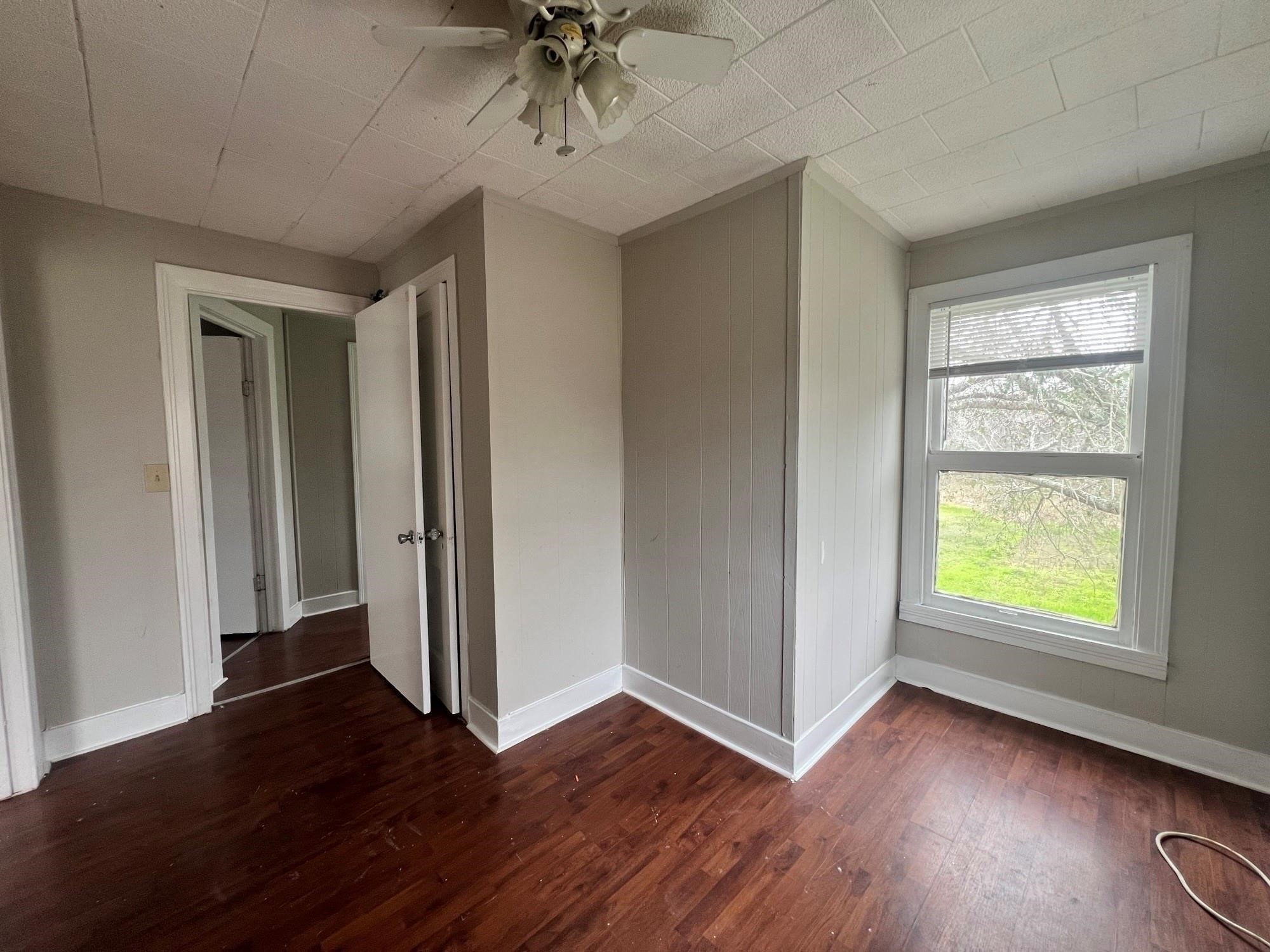 312 South Pumphrey Street Edna, TX 77957 - Photo 5 of 12 an empty room with wooden floor closet and windows