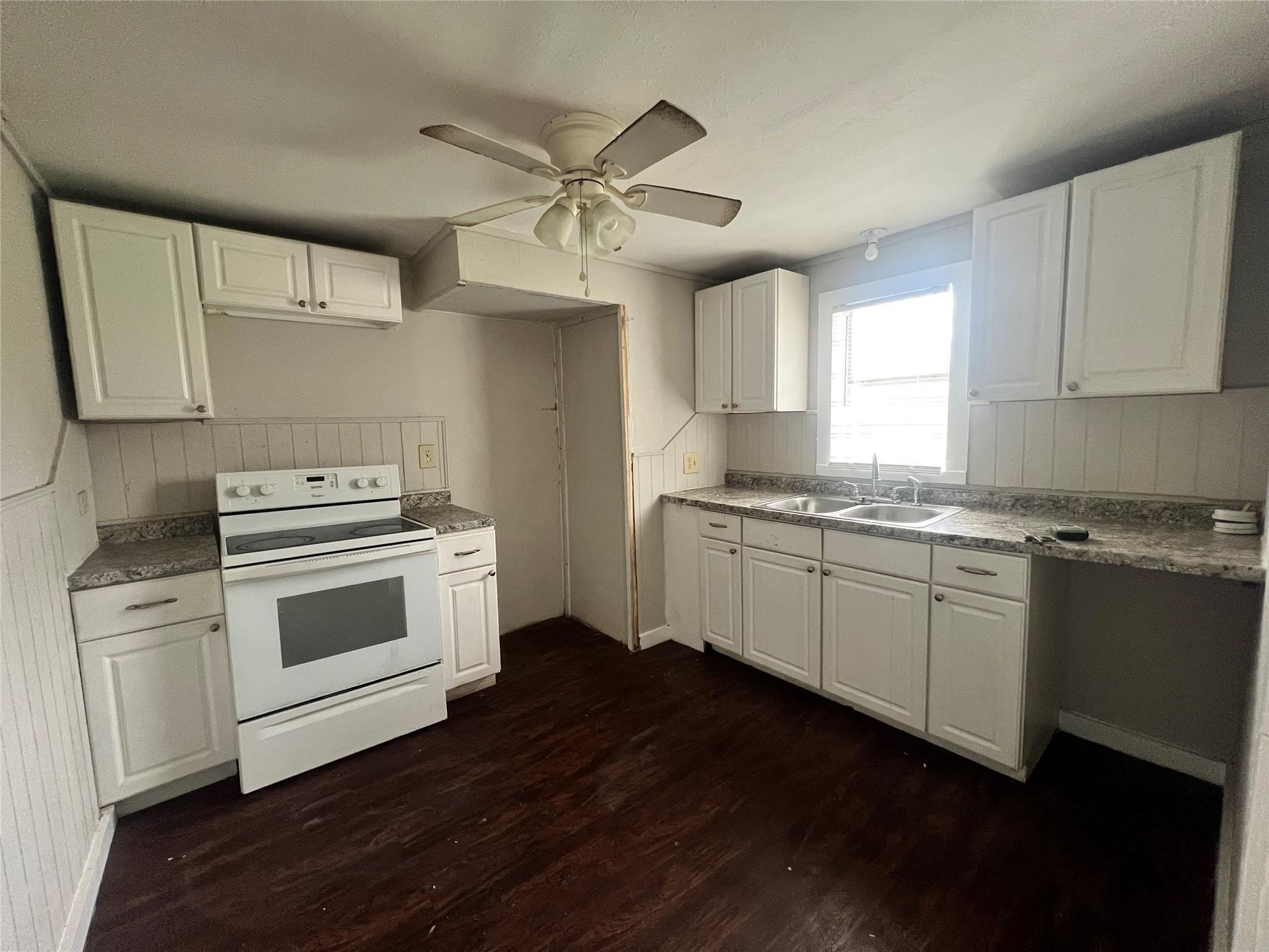 312 South Pumphrey Street Edna, TX 77957 - Photo 8 of 12 a kitchen with granite countertop white cabinets and white appliances