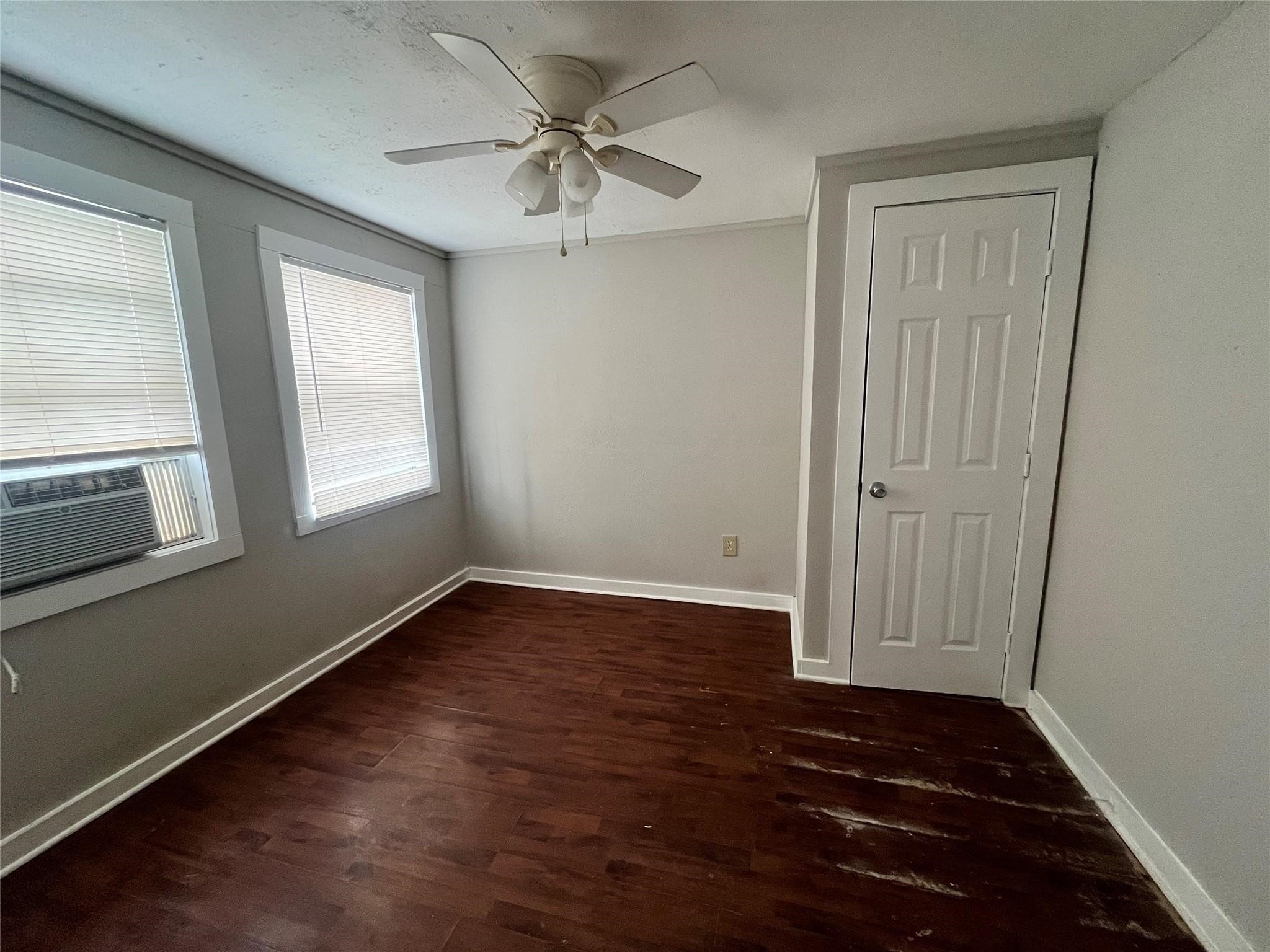 312 South Pumphrey Street Edna, TX 77957 - Photo 9 of 12 a view of an empty room with wooden floor and a window