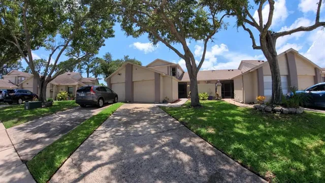 a front view of a house with a garden and trees