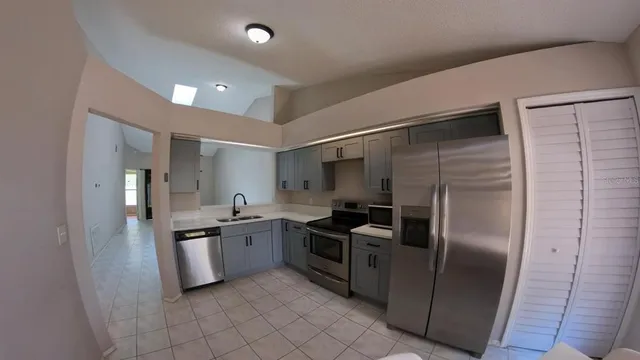 a kitchen with stainless steel appliances granite countertop a refrigerator and a sink