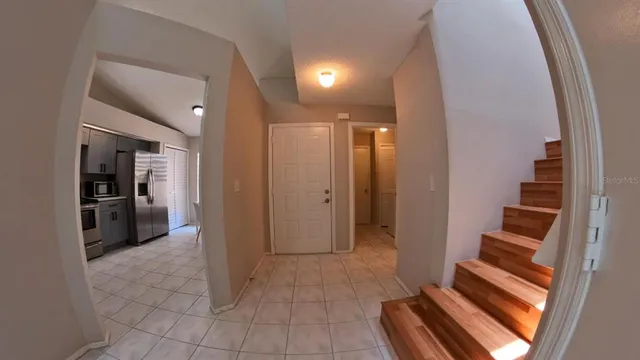 a view of a hallway with wooden floor and a bathroom