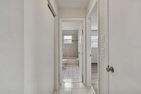 an empty room with wooden floor ceiling fan and window