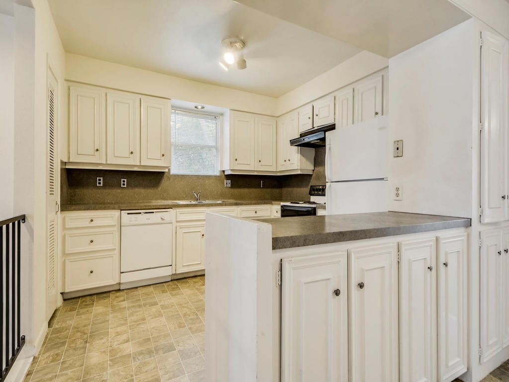 2819 San Gabriel Street, Unit B Austin, TX 78705 - Photo 10 of 20 a kitchen with granite countertop white cabinets and stainless steel appliances
