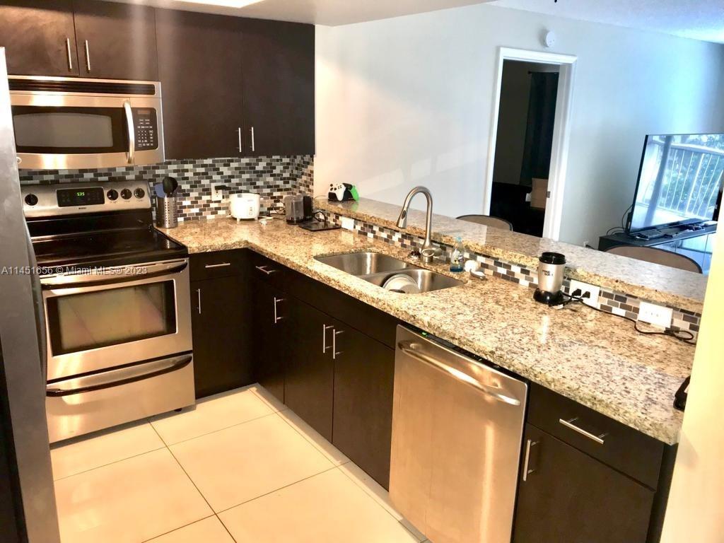 430 South Park Road, Unit 3302 Hollywood, FL 33021 - Photo 3 of 31 a kitchen with granite countertop a sink and stainless steel appliances