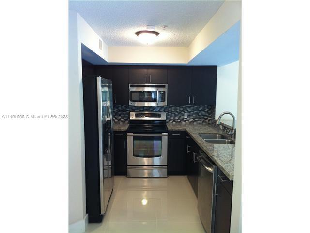 430 South Park Road, Unit 3302 Hollywood, FL 33021 - Photo 4 of 31 a kitchen with stainless steel appliances granite countertop a stove and a refrigerator
