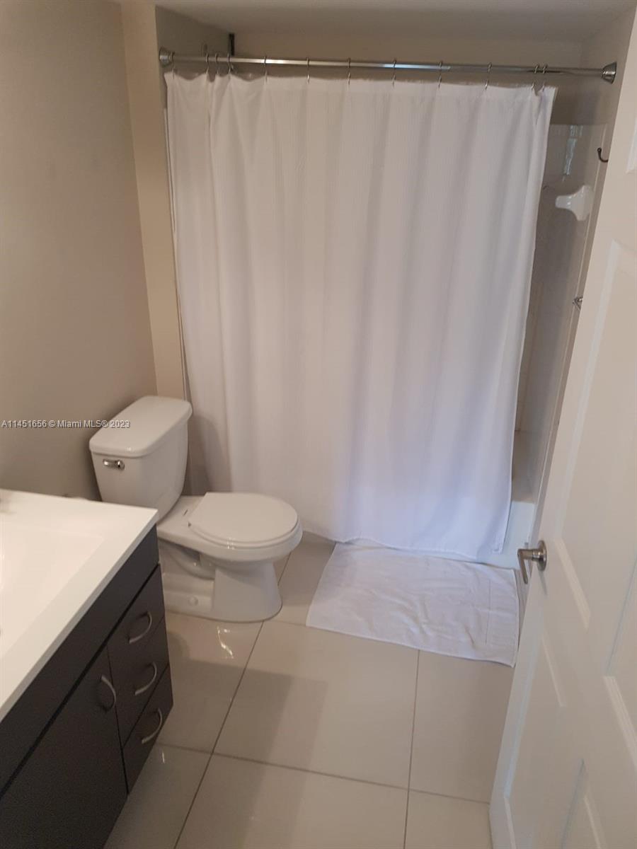 430 South Park Road, Unit 3302 Hollywood, FL 33021 - Photo 8 of 31 a bathroom with a toilet and a shower curtain