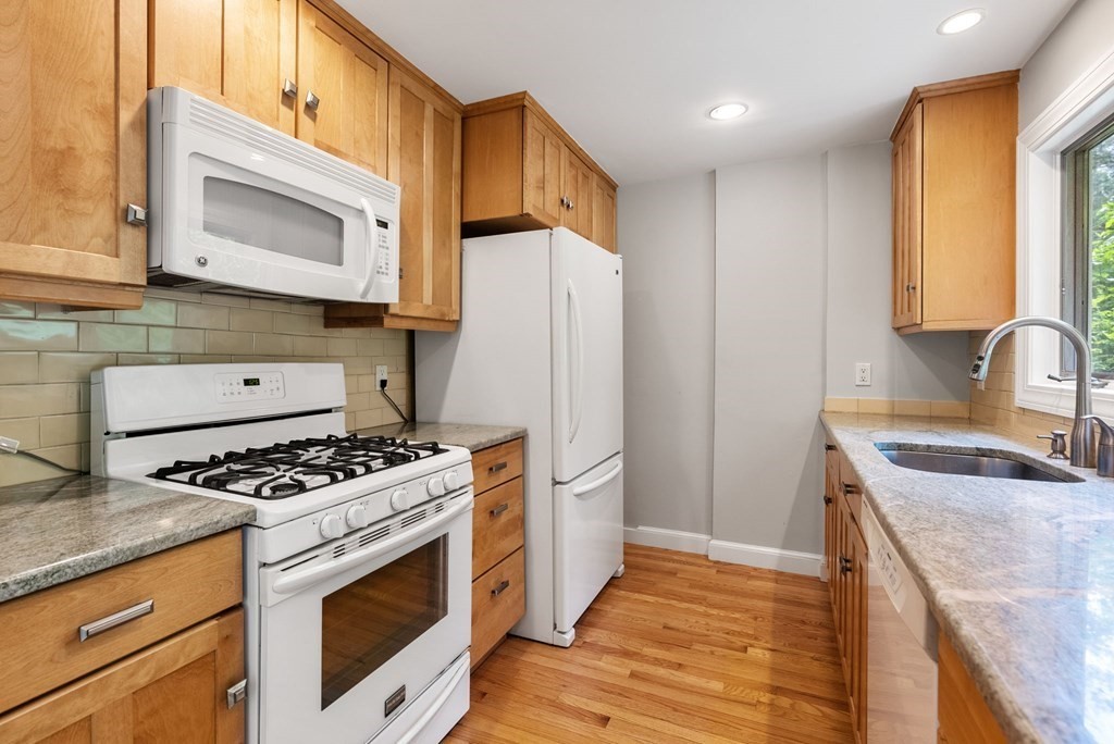 56 River Road Weston, MA 02493 - Photo 9 of 23 a kitchen with granite countertop a sink stove and refrigerator