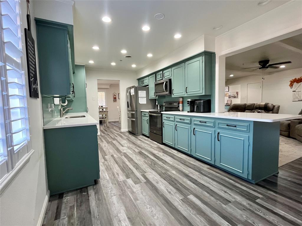 5302 Vale Street Greenville, TX 75402 - Photo 7 of 33 a kitchen with kitchen island a sink stainless steel appliances and cabinets