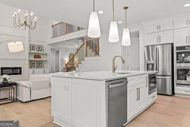 a kitchen with white cabinets and stainless steel appliances