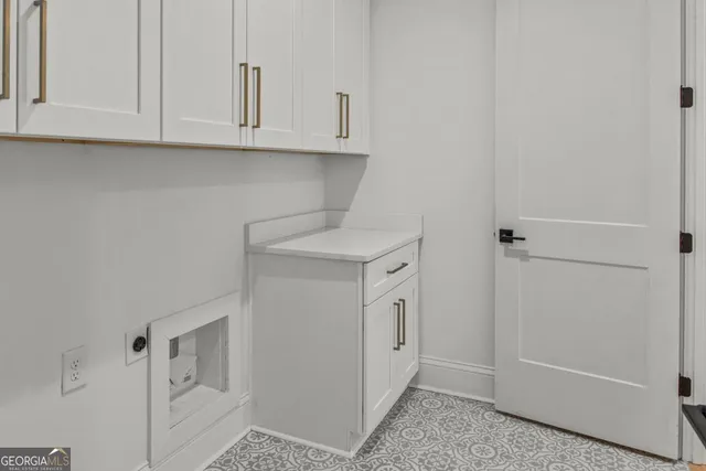 a view of cabinets and utility room with closet