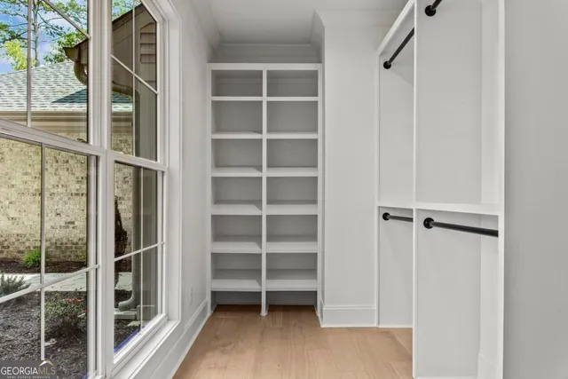 a view of walk in closet with empty racks