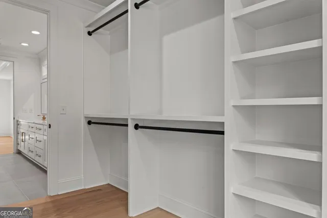 a view of walk in closet with empty racks