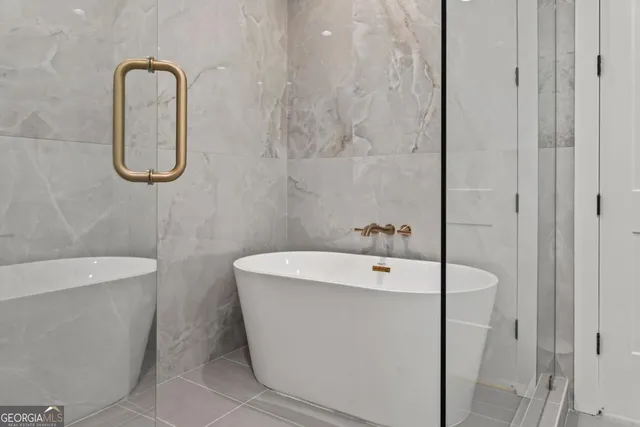 a bathroom with a white bath tub a sink and mirror