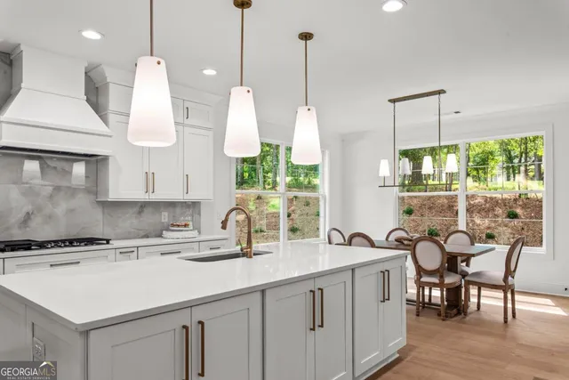 a kitchen with stainless steel appliances granite countertop a sink a stove and a wooden floors