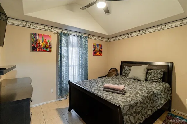 a large bedroom with a bed and wooden floor