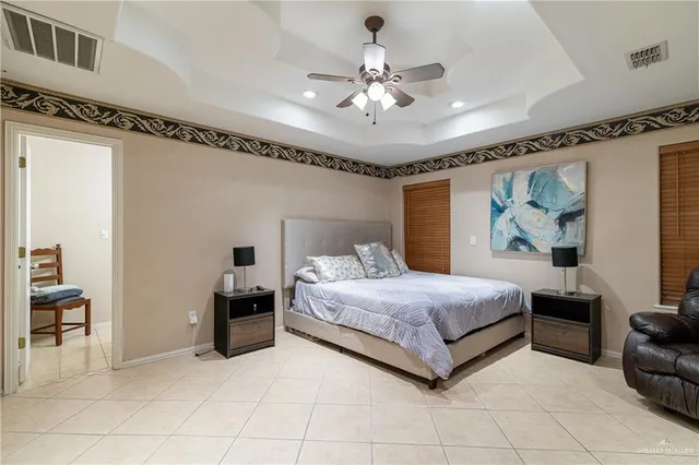 a spacious bedroom with a bed and a chandelier